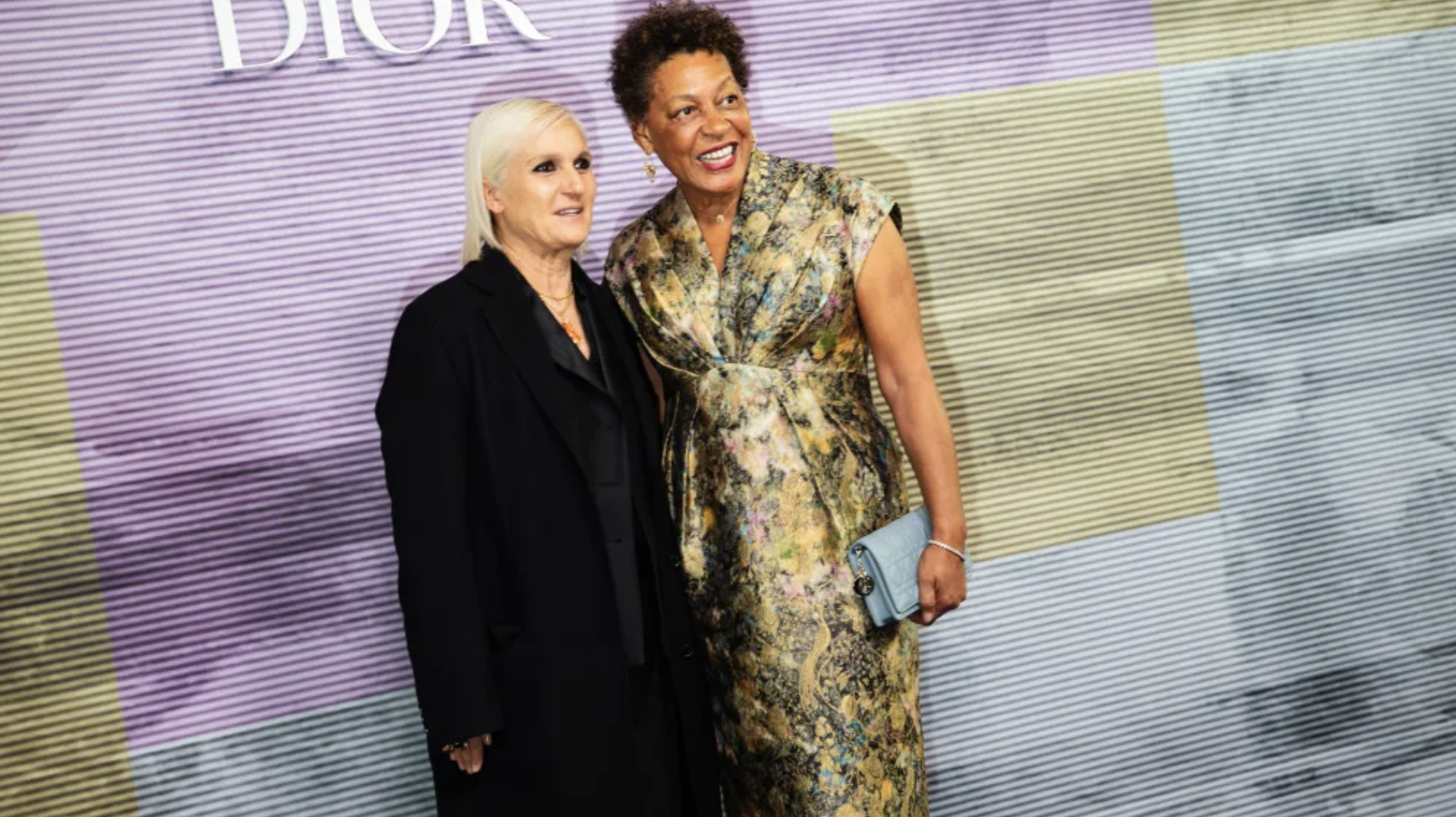 At a Dior event, two women stand together, their fashion choices symbolizing strength, solidarity, and empowerment.